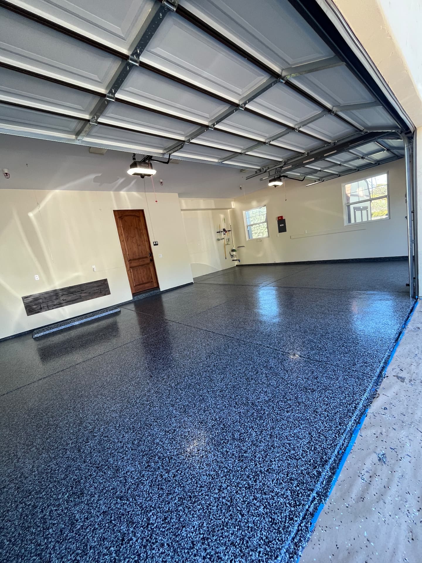 Two-Car Flake Garage — Diamond-ground slab, 100% solids base, full-broadcast 1/4" black, gray and white flake, polyaspartic clear top coat