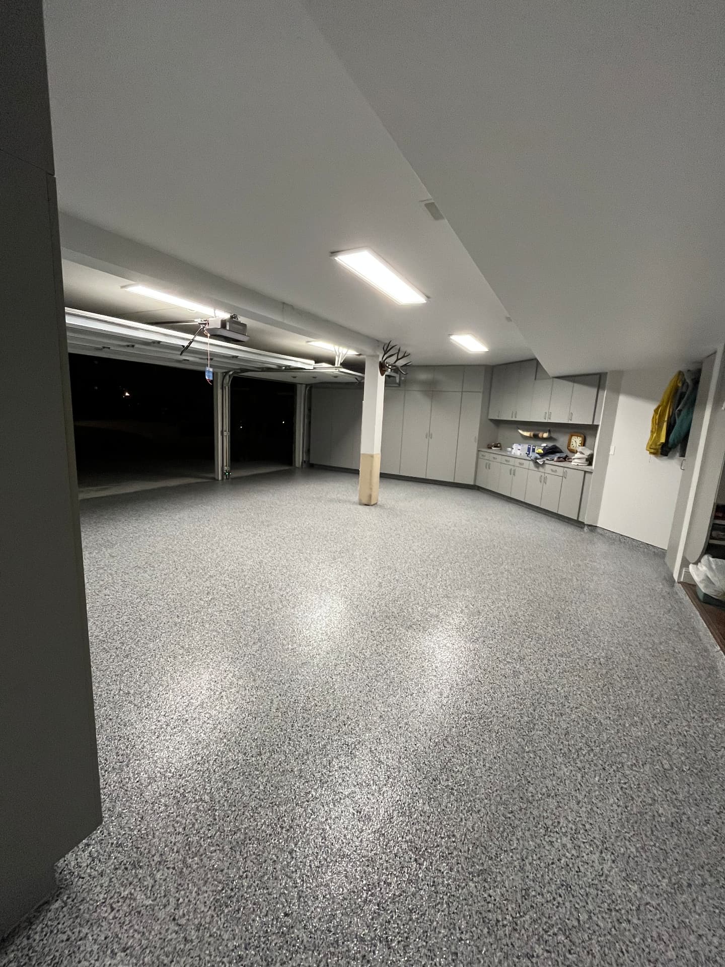Three-Car Flake Garage — Ground and crack-filled slab, 100% solids base, full-broadcast 1/4" black, white and gray flake, polyaspartic top coat